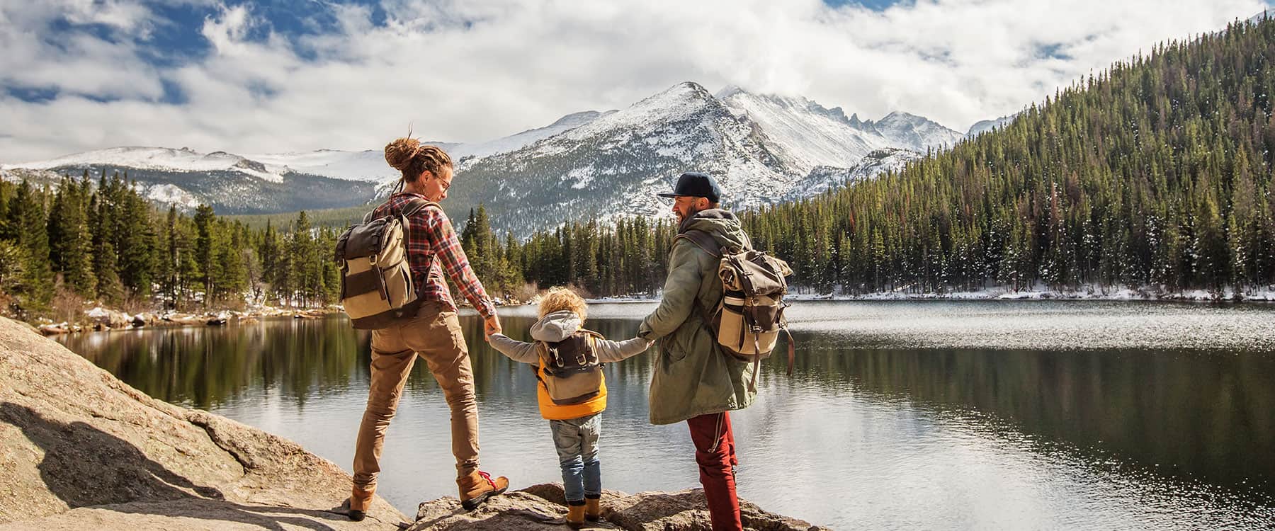 Family hiking beside a mountain lake